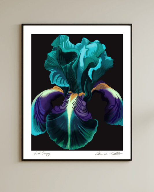 Framed artwork of a colorful green, purple, and orange iris flower with a black background and a white border on a beige wall.