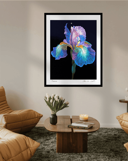 Framed artwork of a rainbow colored iris flower on a beige wall in a trendy living room with hipster chairs and vase of white tulips on a coffee table. 